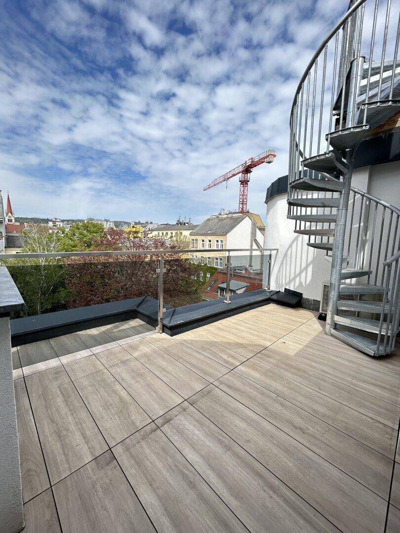 Dachterrasse mit Wendeltreppe und Glasgeländer bietet einen weiten Blick über die Stadt.