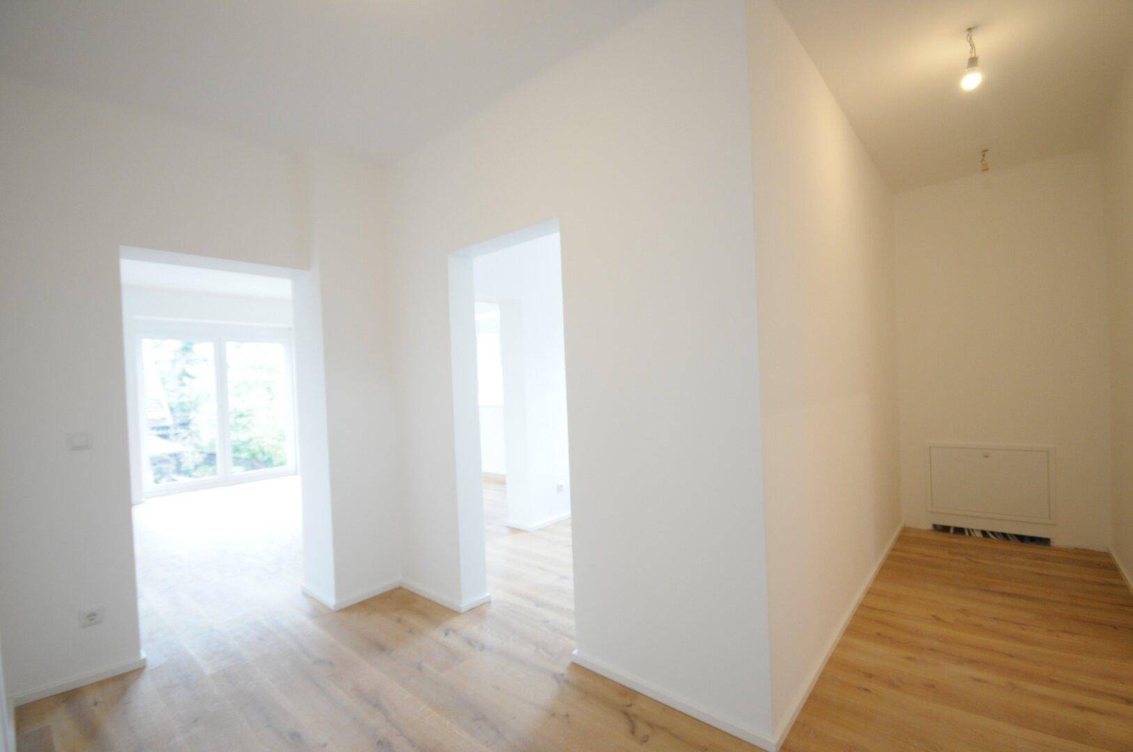 Heller Flur mit Holzboden, der zu weiteren Räumen führt und einen offenen Eindruck vermittelt.