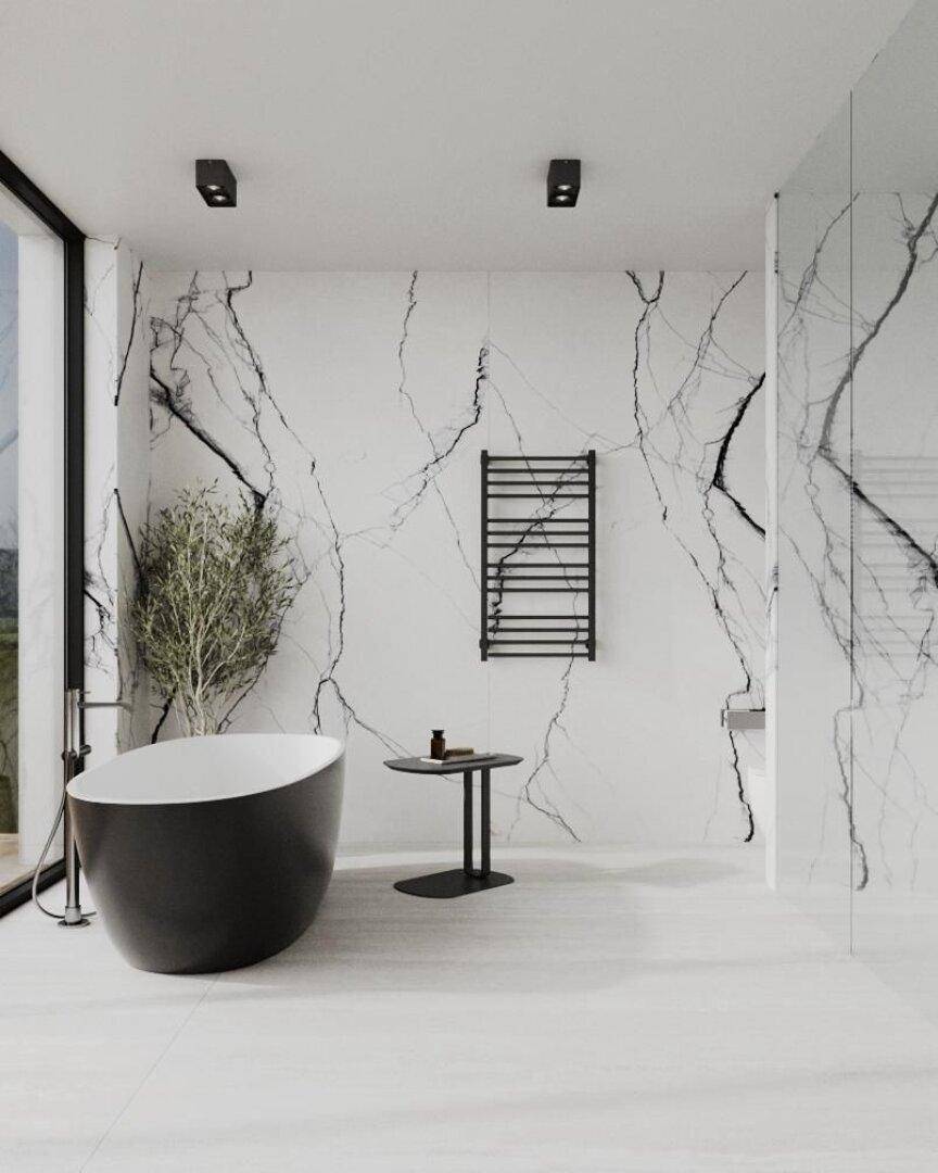 Elegantes Badezimmer mit freistehender Badewanne, Marmorwänden und beheiztem Handtuchhalter.