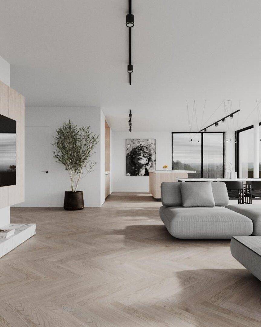 Heller, offener Wohnbereich mit Holzboden, modernem Sofa und Blick auf die Küche.