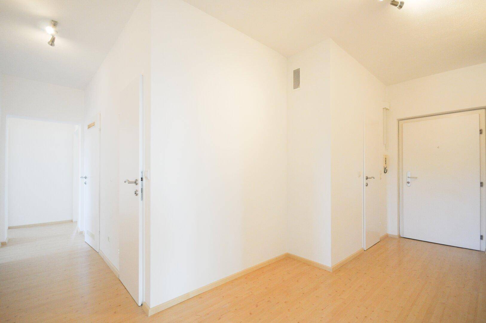 Heller Flur mit Parkettboden und mehreren Türen, die zu den verschiedenen Zimmern führen.