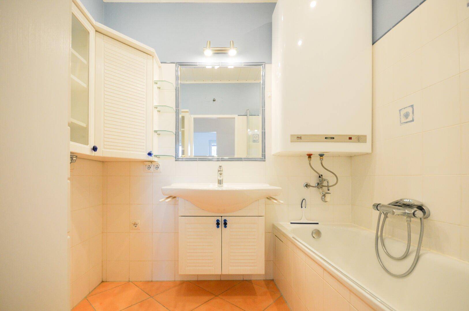 Badezimmer mit Waschbecken, Spiegelschrank und Badewanne, in einem hellen und funktionalen Design.