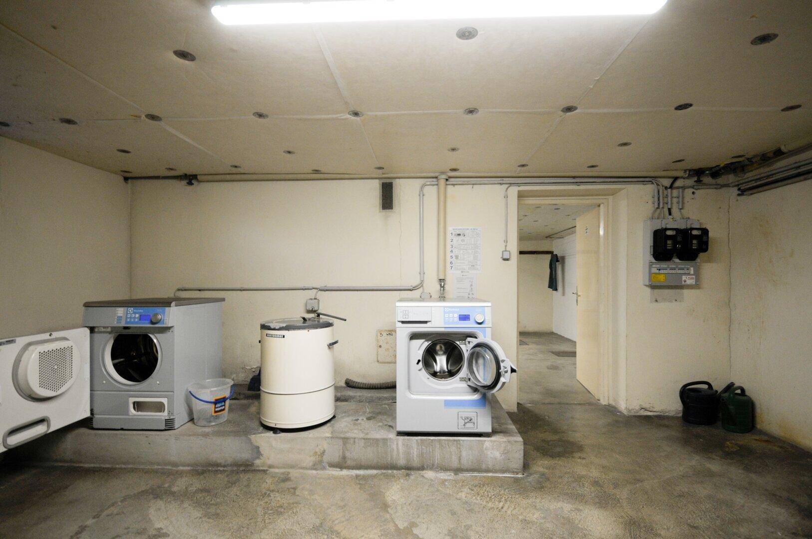 Gemeinschaftlicher Waschraum im Keller mit Waschmaschinen und Trocknern für die Bewohner.