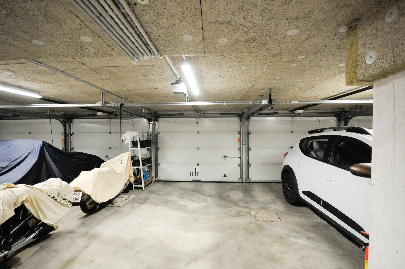 Tiefgarage mit mehreren Stellplätzen und Garagentoren, die sich unter dem Gebäude befindet.