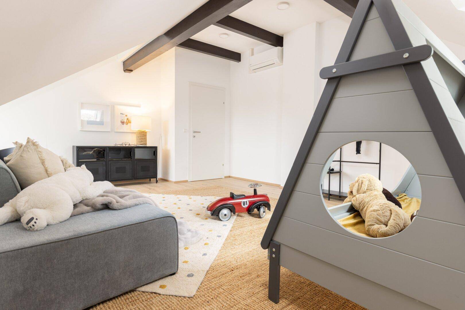 Spielbereich im Kinderzimmer mit Holzbalken und Spielzeug.