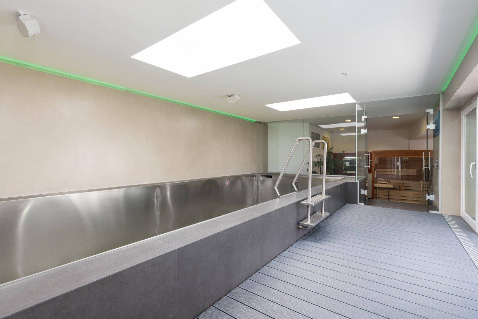 Innenpoolbereich mit modernem Design, Oberlichtern und Zugang zur Sauna.
