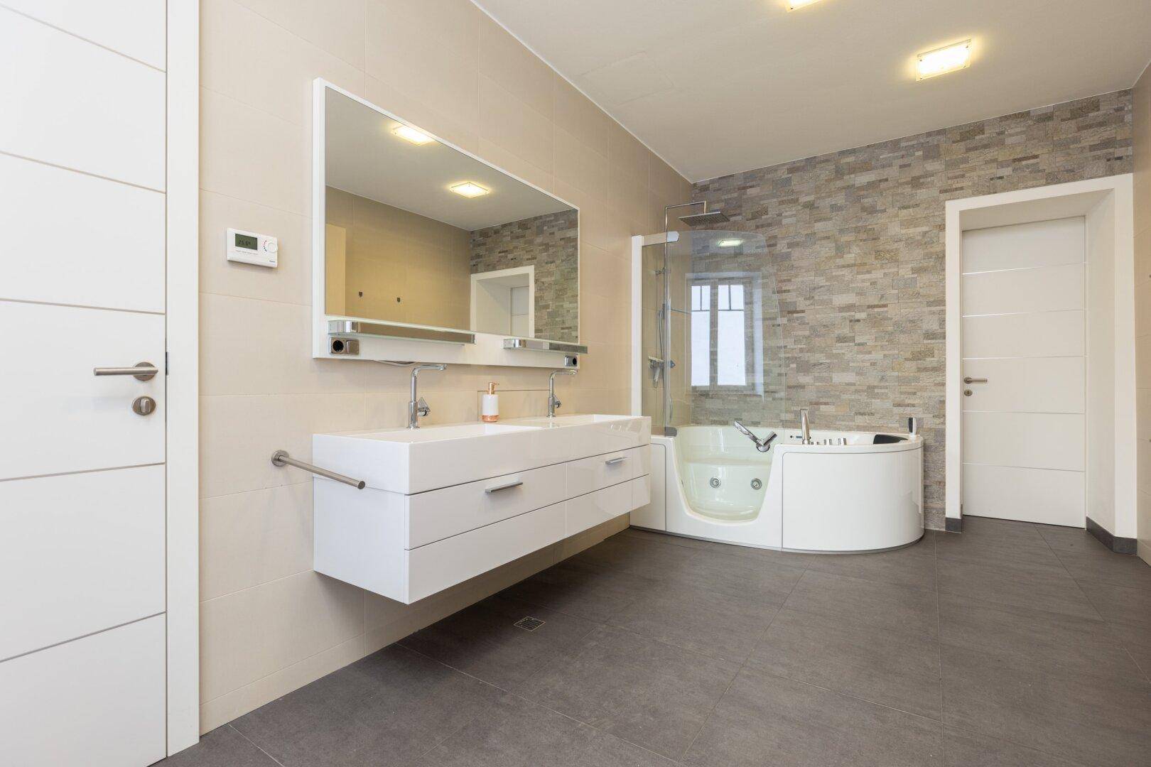 Modernes Badezimmer mit Doppelwaschbecken, Badewanne und begehbarer Dusche.