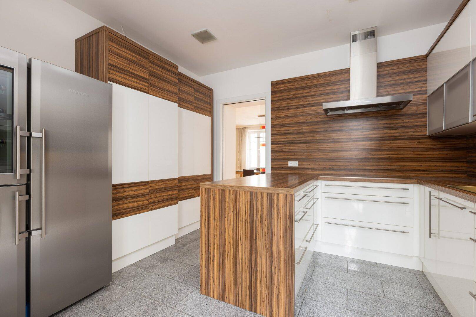 Moderne Küche mit Holz- und weißen Fronten, Edelstahlkühlschrank und Kochinsel.