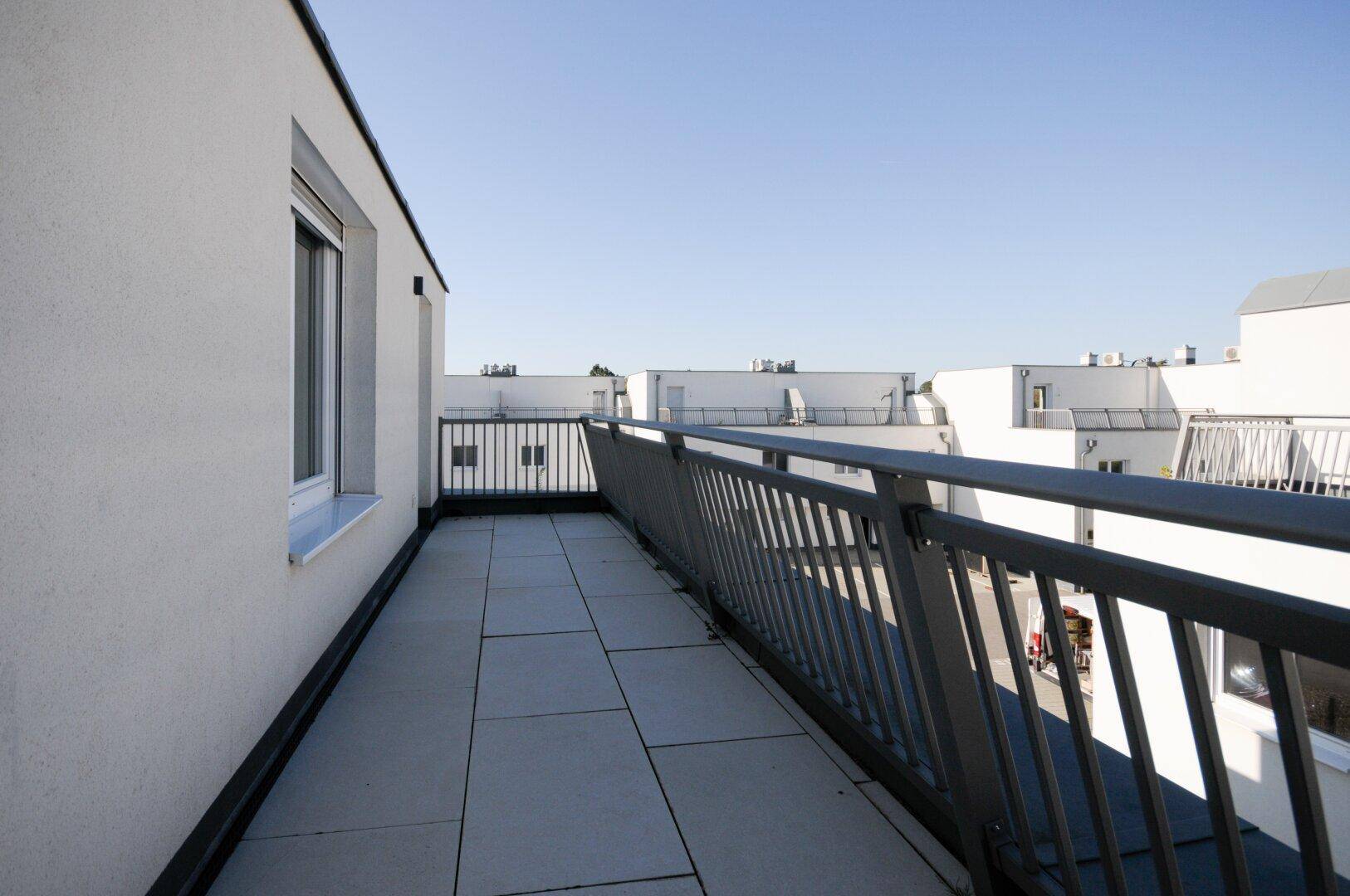 Weitläufige Terrasse mit Blick auf die umliegenden Gebäude und den blauen Himmel.
