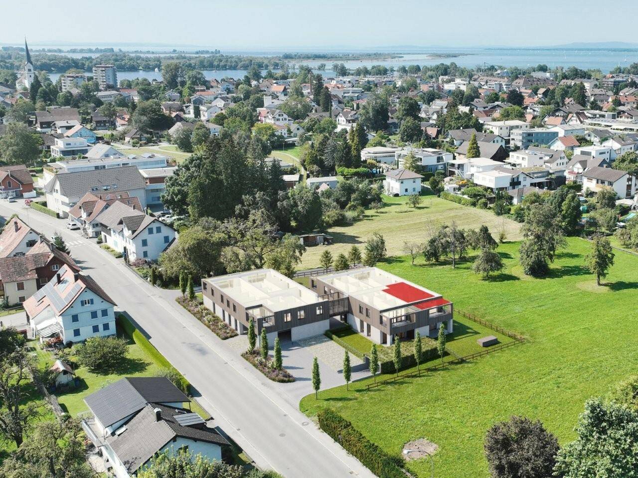 Luftaufnahme der neuen Gebäude in ländlicher Umgebung mit weitem Blick auf den See.