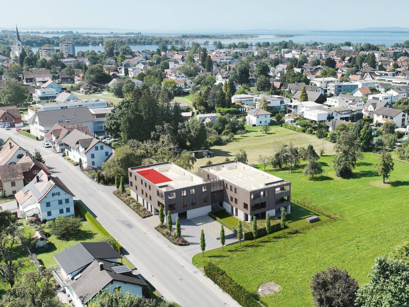Luftaufnahme der modernen Wohnanlage in grüner Umgebung mit Blick auf den See.