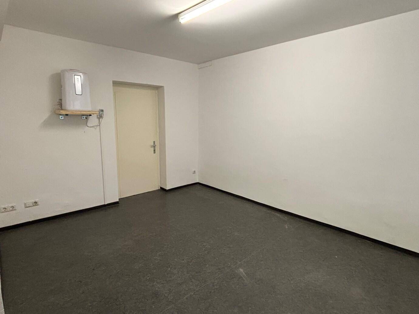 Leerer, heller Raum mit weiß gestrichenen Wänden und einem einfachen Eingangsbereich.