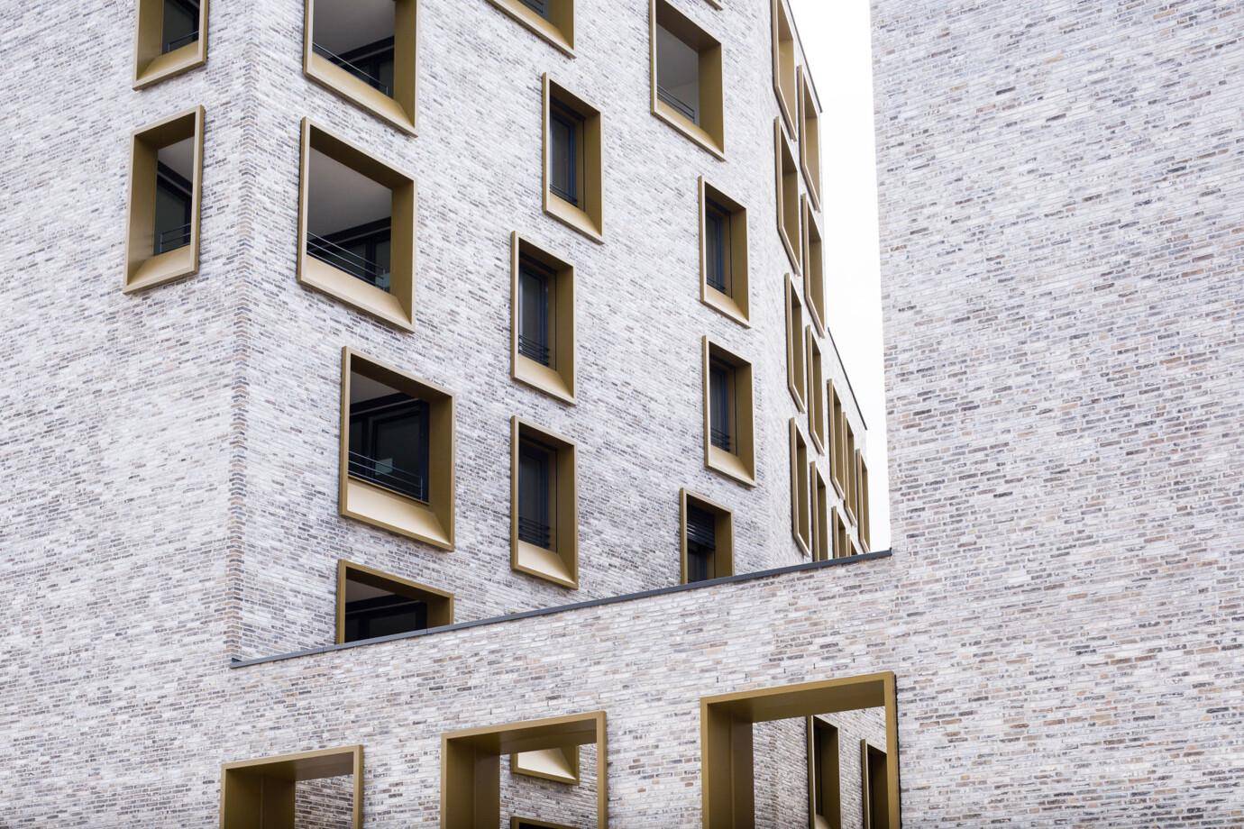 Nahaufnahme der Fassade mit hellen Ziegeln und den charakteristischen Fensteröffnungen.