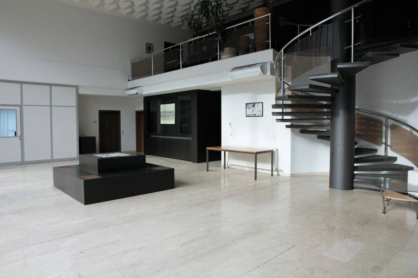 Geräumiger Empfangsbereich mit eleganter Wendeltreppe und Marmorboden.
