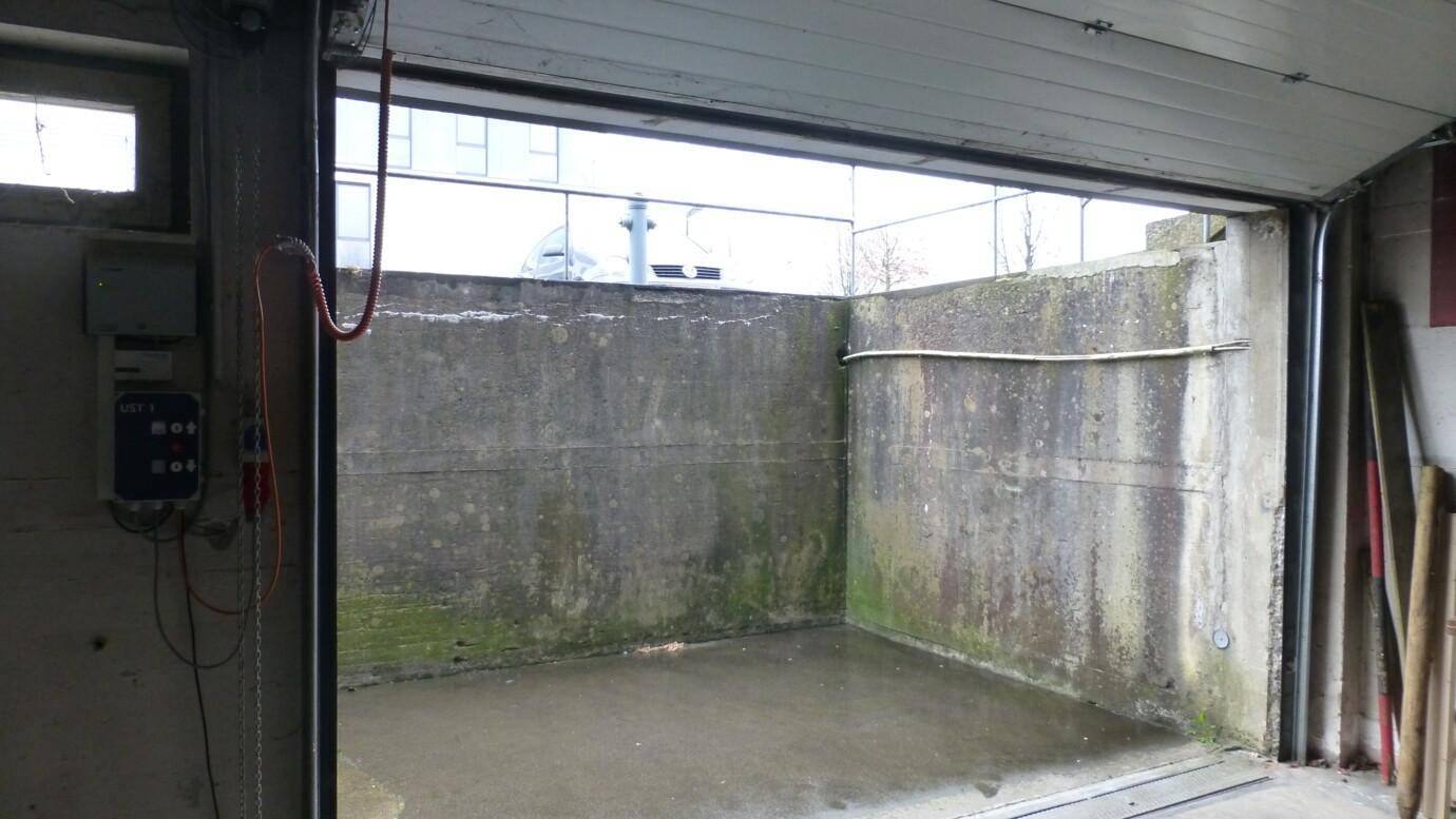 Einfahrt zu einer Tiefgarage oder einem Lagerbereich mit robusten Betonwänden.