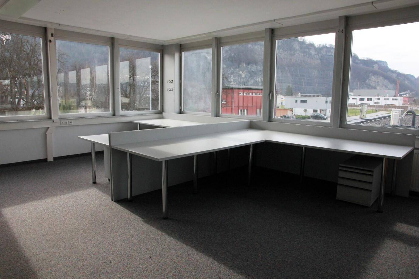 Modernes Büro mit großen Fenstern, die einen weiten Blick auf die Berge bieten.