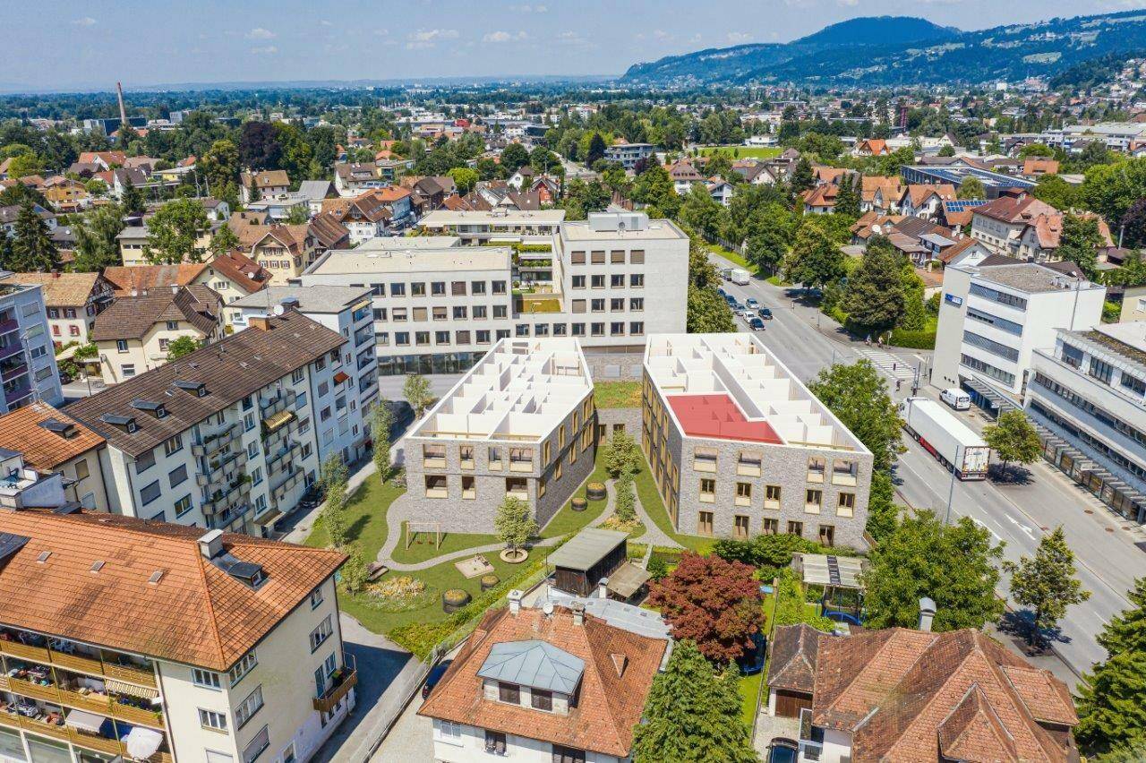 Luftaufnahme von modernen Neubauten mit begrünten Innenhöfen in einer städtischen Umgebung.