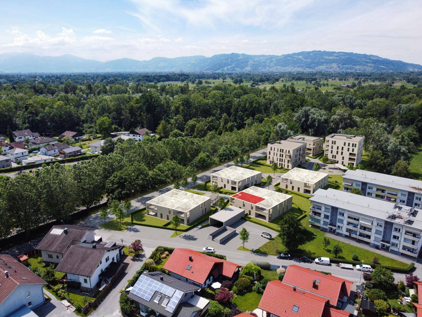Luftaufnahme einer Wohnsiedlung mit sechs im Bau befindlichen Mehrfamilienhäusern, umgeben von bestehenden Häusern und Wald
