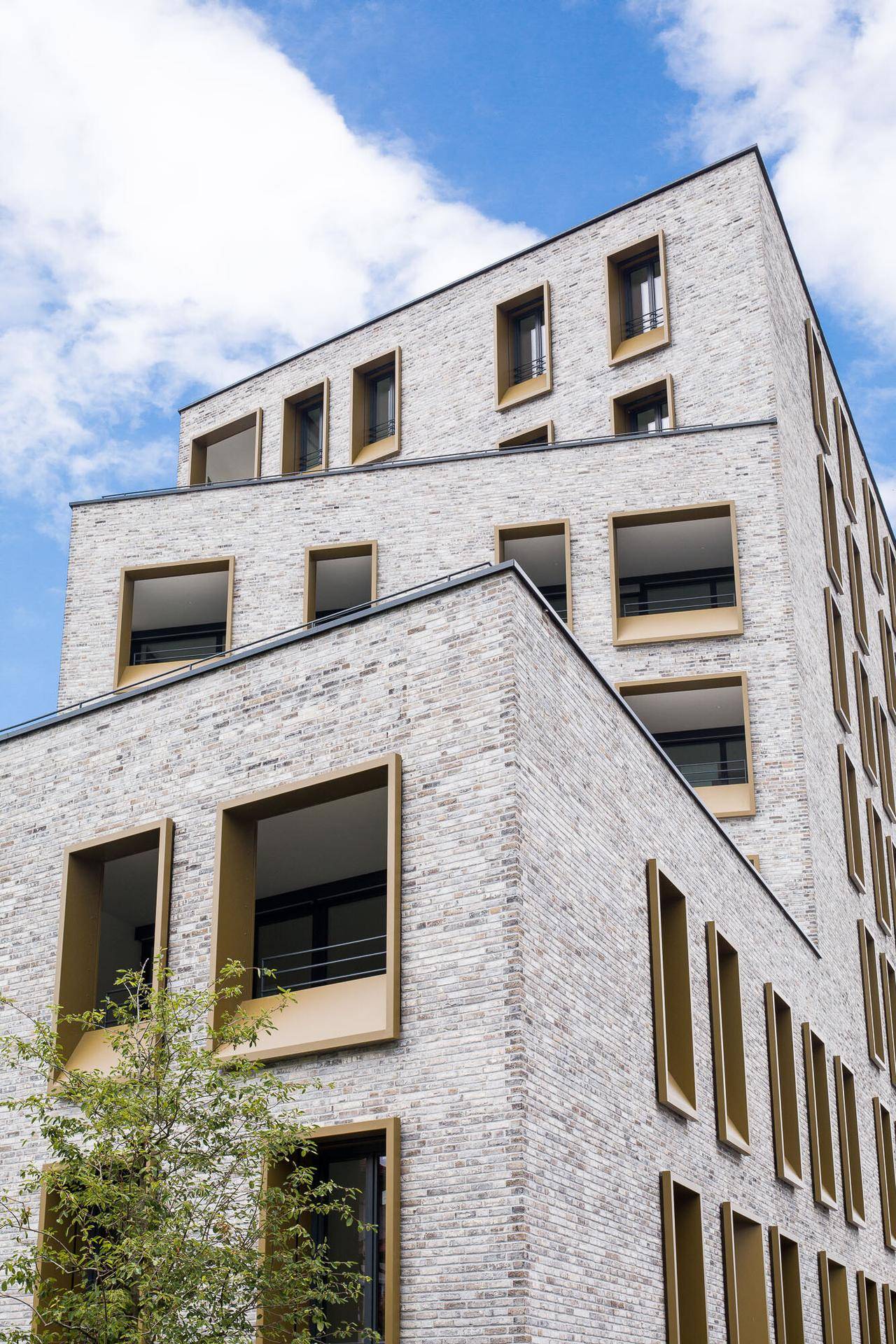 Architektonische Ansicht des modernen Gebäudes mit gestuften Fassaden und großen Fenstern.