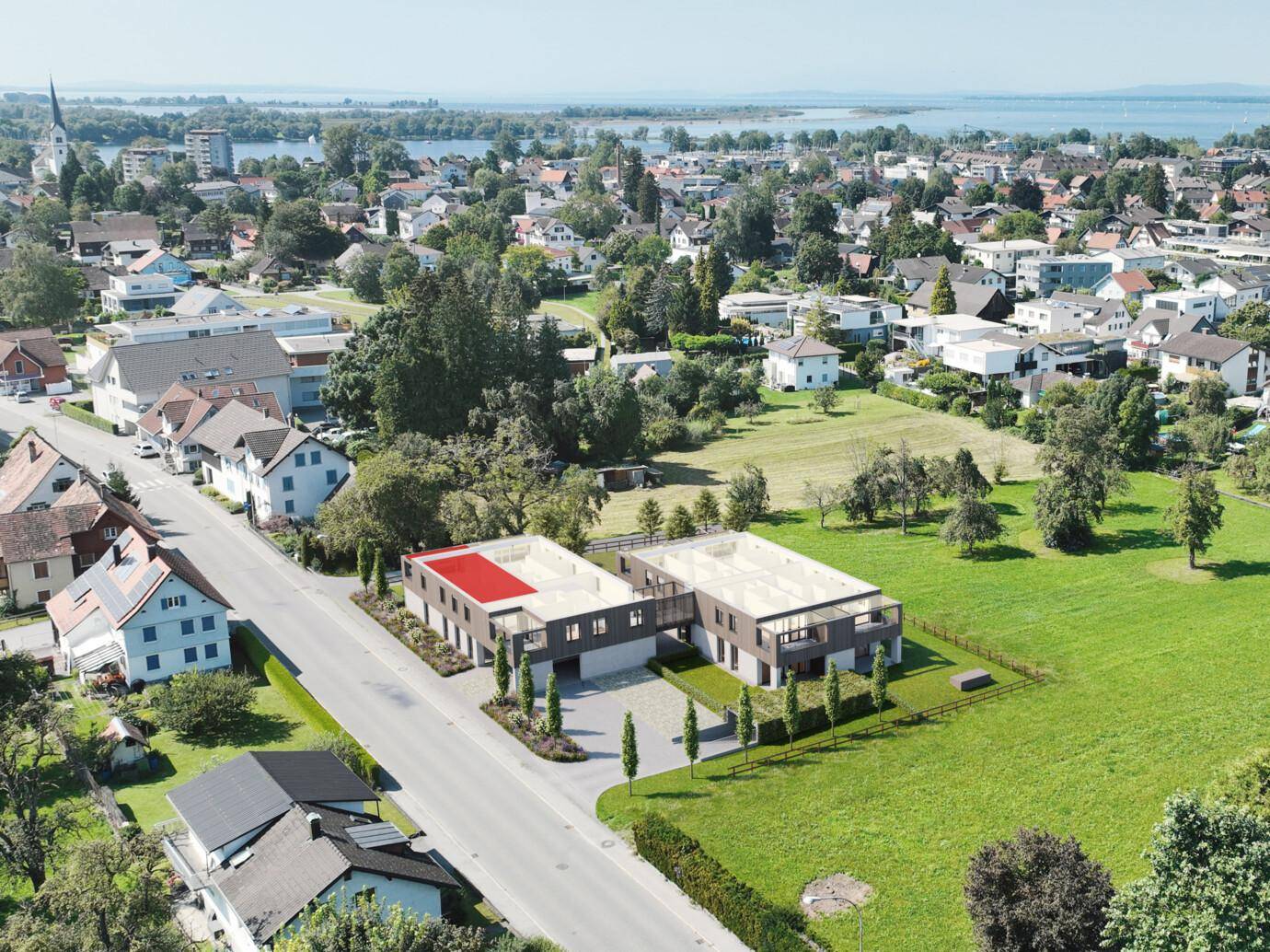 Luftaufnahme der modernen Wohnanlage mit Blick auf den See und die grüne Umgebung.