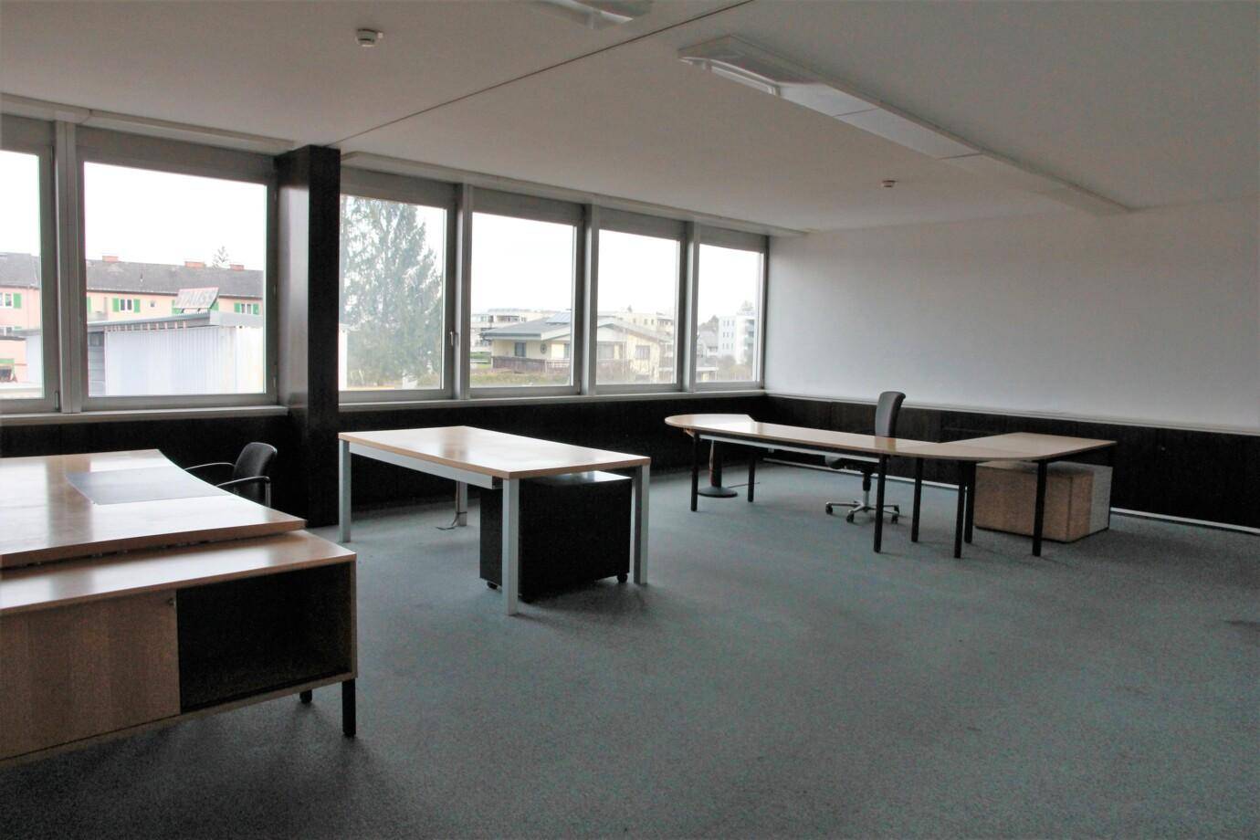 Geräumiges Büro mit mehreren Arbeitsplätzen und Blick auf die Umgebung.