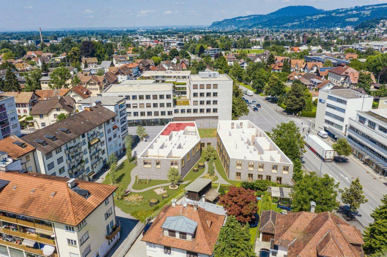 Luftaufnahme eines Neubauprojekts mit modernen Gebäuden, grünen Außenbereichen und städtischer Umgebung.