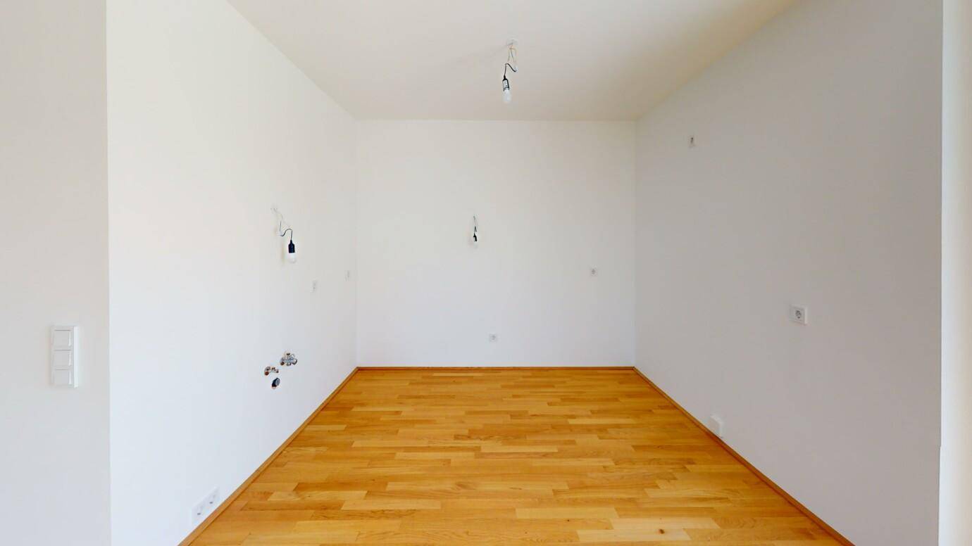 Geräumiger, heller Raum mit Parkettboden und weißen Wänden, ideal für individuelle Gestaltung.
