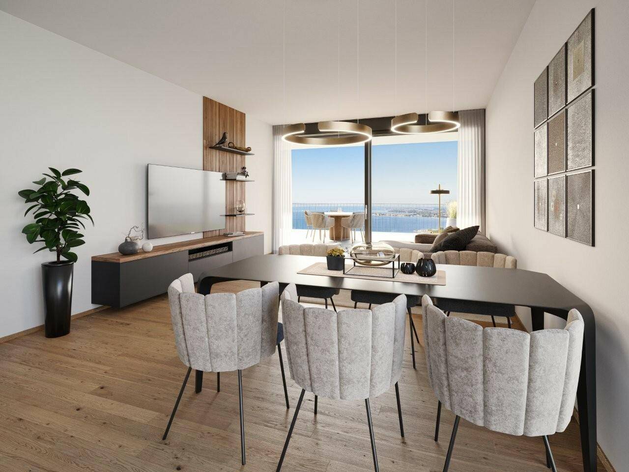 Modern eingerichtetes Wohnzimmer mit Esstisch, Fernseher, Pflanzen und einem Balkon mit Meerblick in der Wohnanlage Pfänderhöhe Lochau.