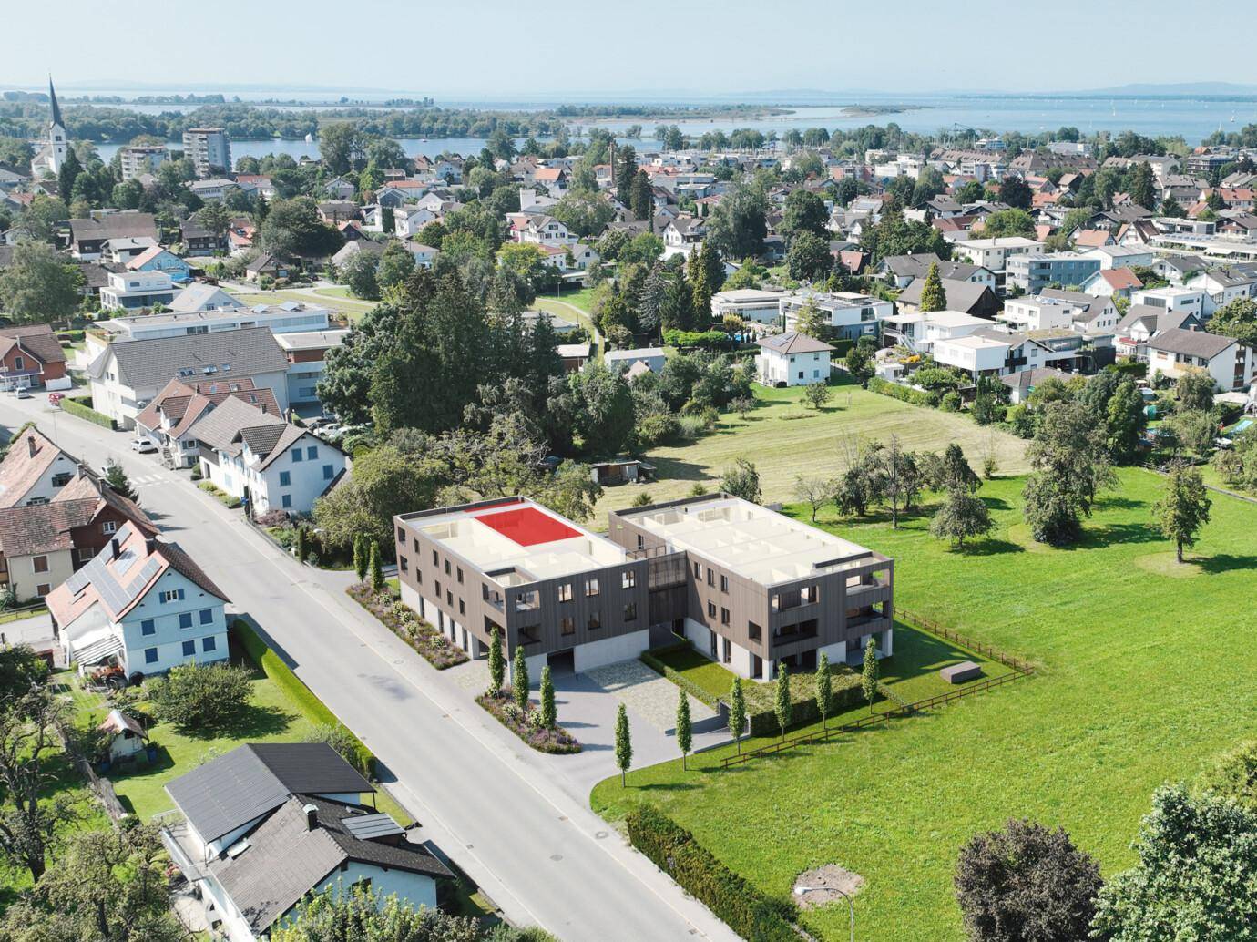 Luftaufnahme der modernen Wohngebäude in grüner Umgebung mit Blick auf den See.