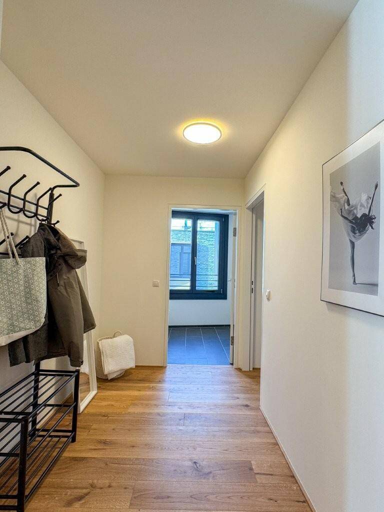 Heller Flur mit Holzboden, Garderobe und Zugang zu weiteren Räumen.