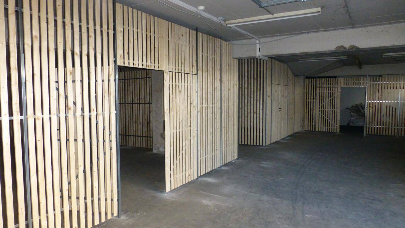 Geräumiger Lagerraum im Keller mit Holzlattenabtrennungen und Betonboden.