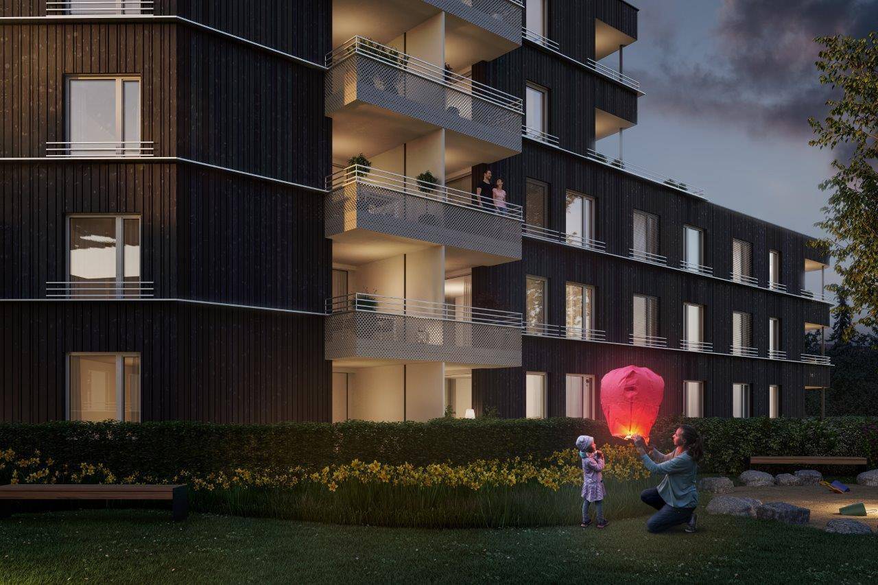 Abendliche Szene im Gartenbereich eines modernen Wohngebäudes mit Spielplatz und Laternen.