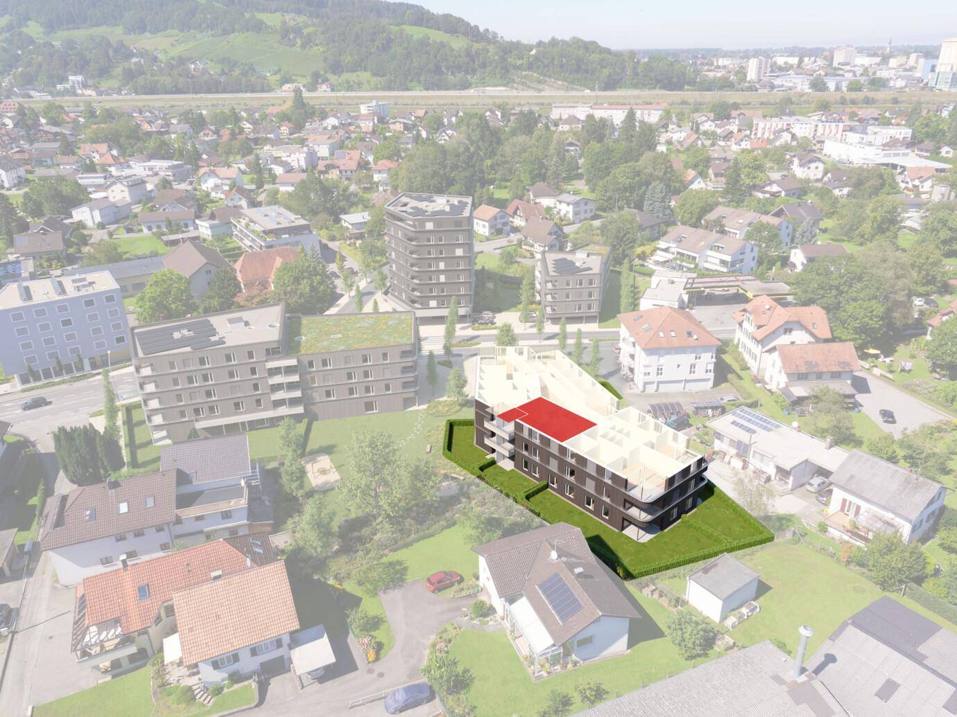 Eine Luftaufnahme, die in Rheindorf ein modernes, teilweise rendering-edifiziertes Gebäude mit Balkonen und roten Dachlinien umgeben von Häusern und grünen Flächen zeigt.