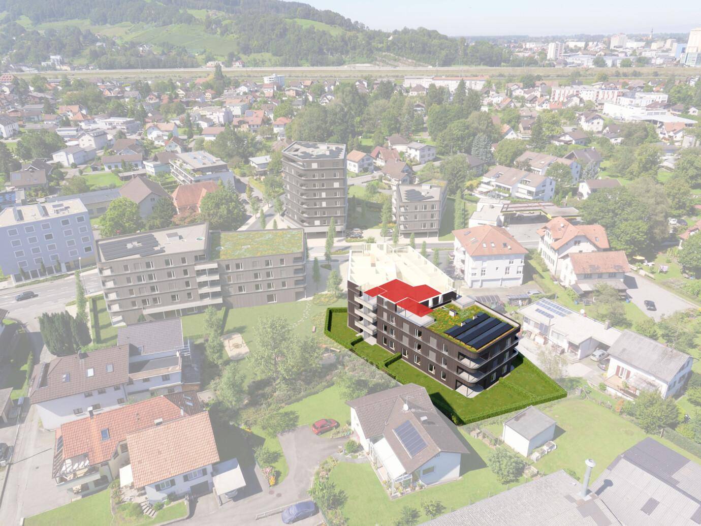 Eine Luftaufnahme eines modernen Wohngebäudes mit Gründach und Solarpaneelen, eingebettet in eine Wohnsiedlung (Rheindorf).