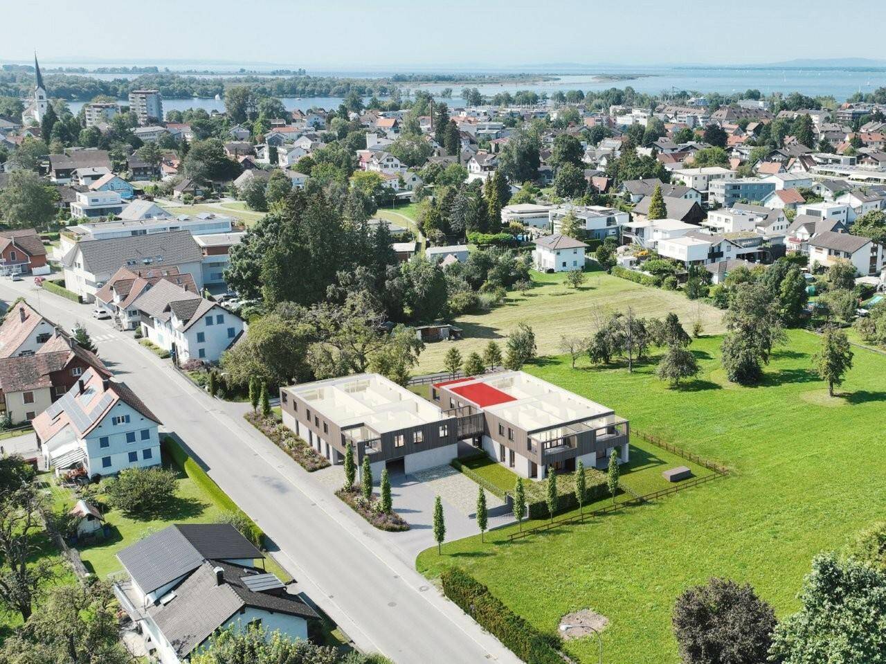 Luftaufnahme der modernen Wohnanlage mit Blick auf den See und die umliegende Stadt.