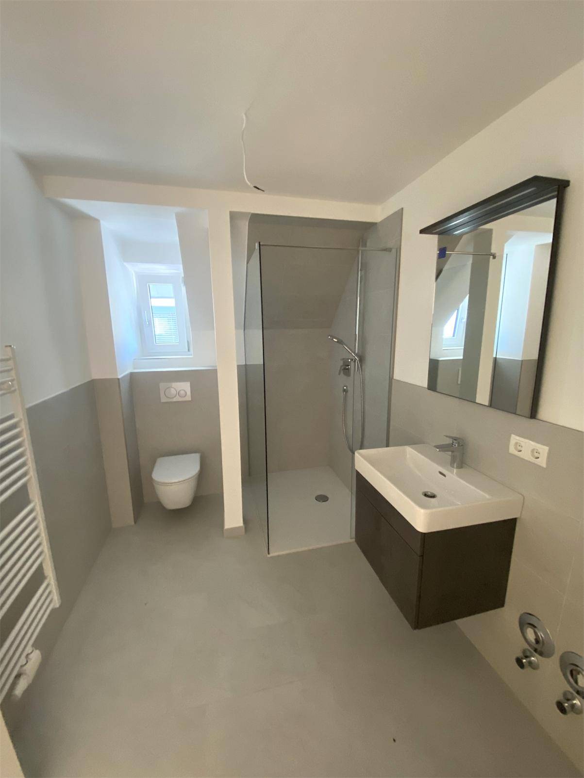 Modernes Badezimmer mit ebenerdiger Dusche, Wand-WC, Einzelwaschbecken und Fenster.