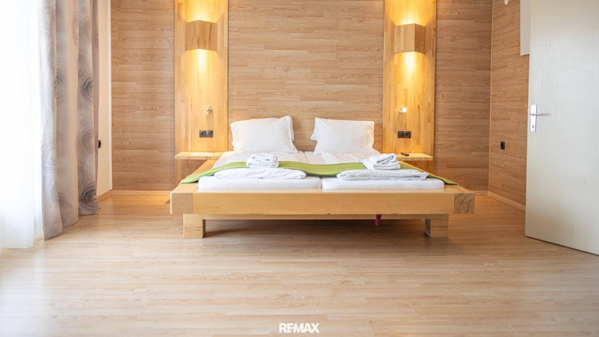 Gemütliches Schlafzimmer mit Holzbett und passender Wandvertäfelung, bietet eine warme Atmosphäre.