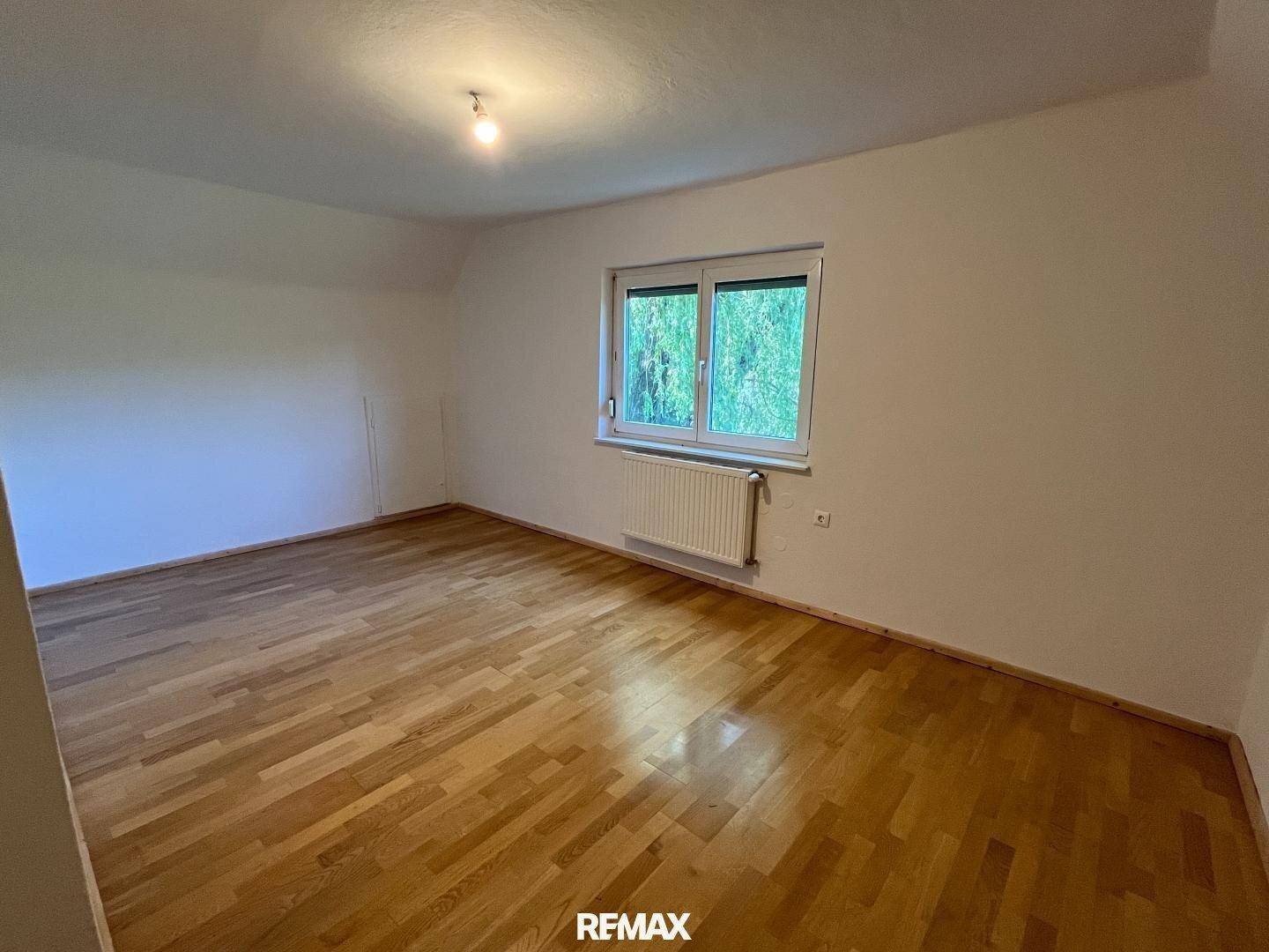 Ruhiges Schlafzimmer mit Holzboden und Fenster, bietet einen angenehmen Rückzugsort.
