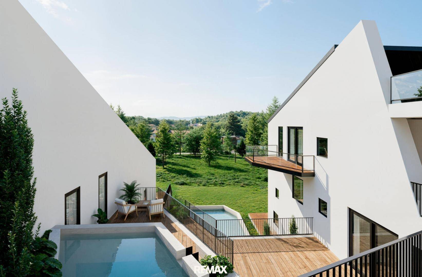Außenbereich mit Holzterrasse, zwei Pools und weitem Blick ins Grüne.