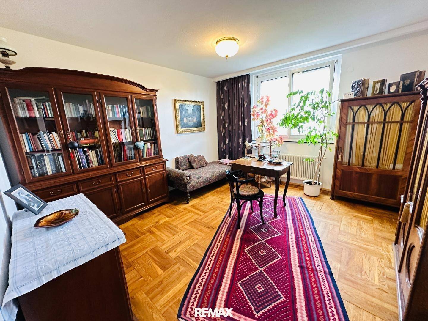 Arbeitszimmer mit Bücherregalen, Schreibtisch und traditionellen Holzmöbeln.