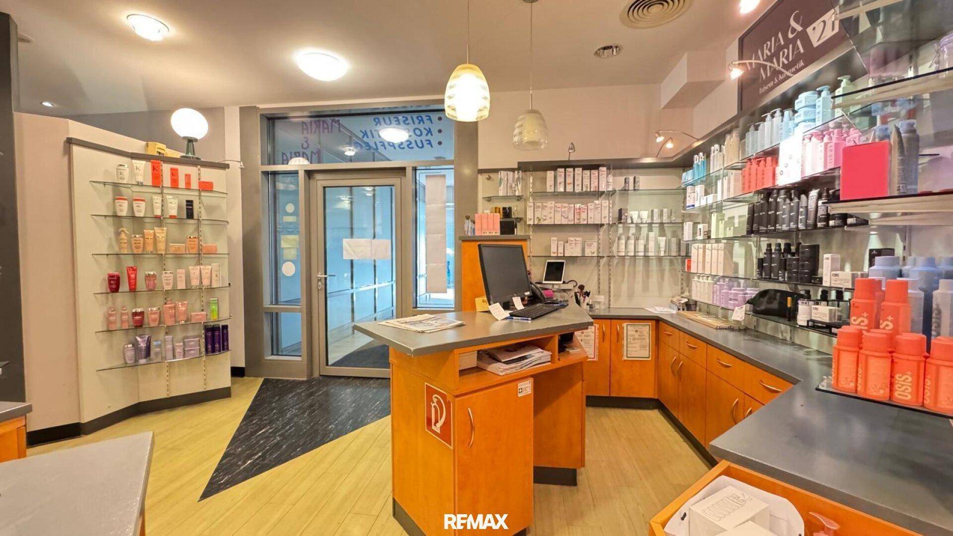 Detailansicht des Salon-Empfangsbereichs mit umfangreichen Produktpräsentationen und Theke.