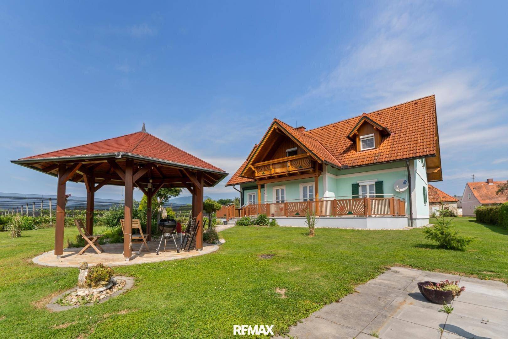 Großer Garten mit Grillplatz, Gartenlaube und Blick auf das Einfamilienhaus.