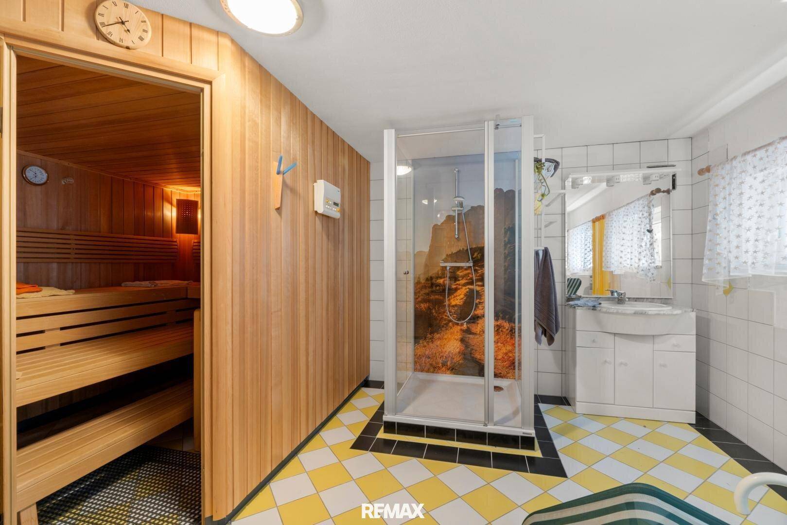 Badezimmer mit Sauna, Duschkabine und gelb-weiß kariertem Fliesenboden.