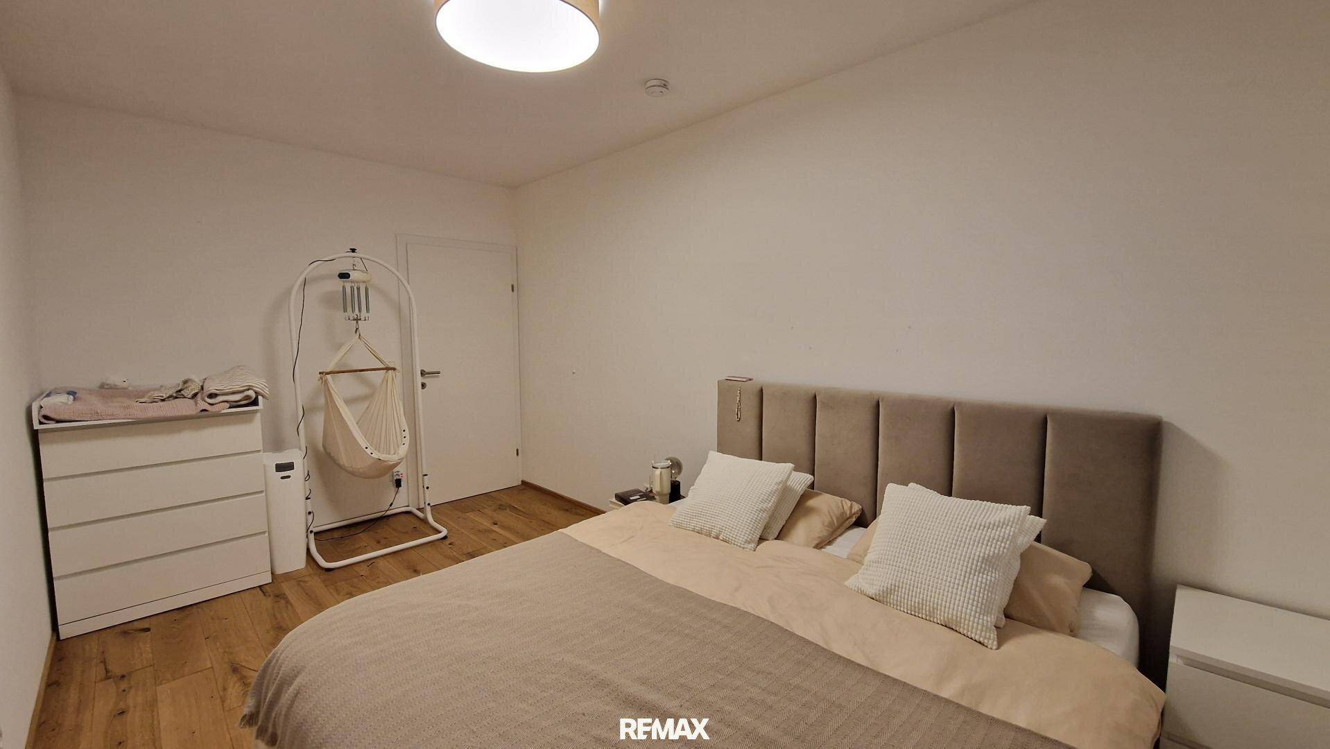 Gemütliches Schlafzimmer mit Doppelbett, Kommode und Holzboden.