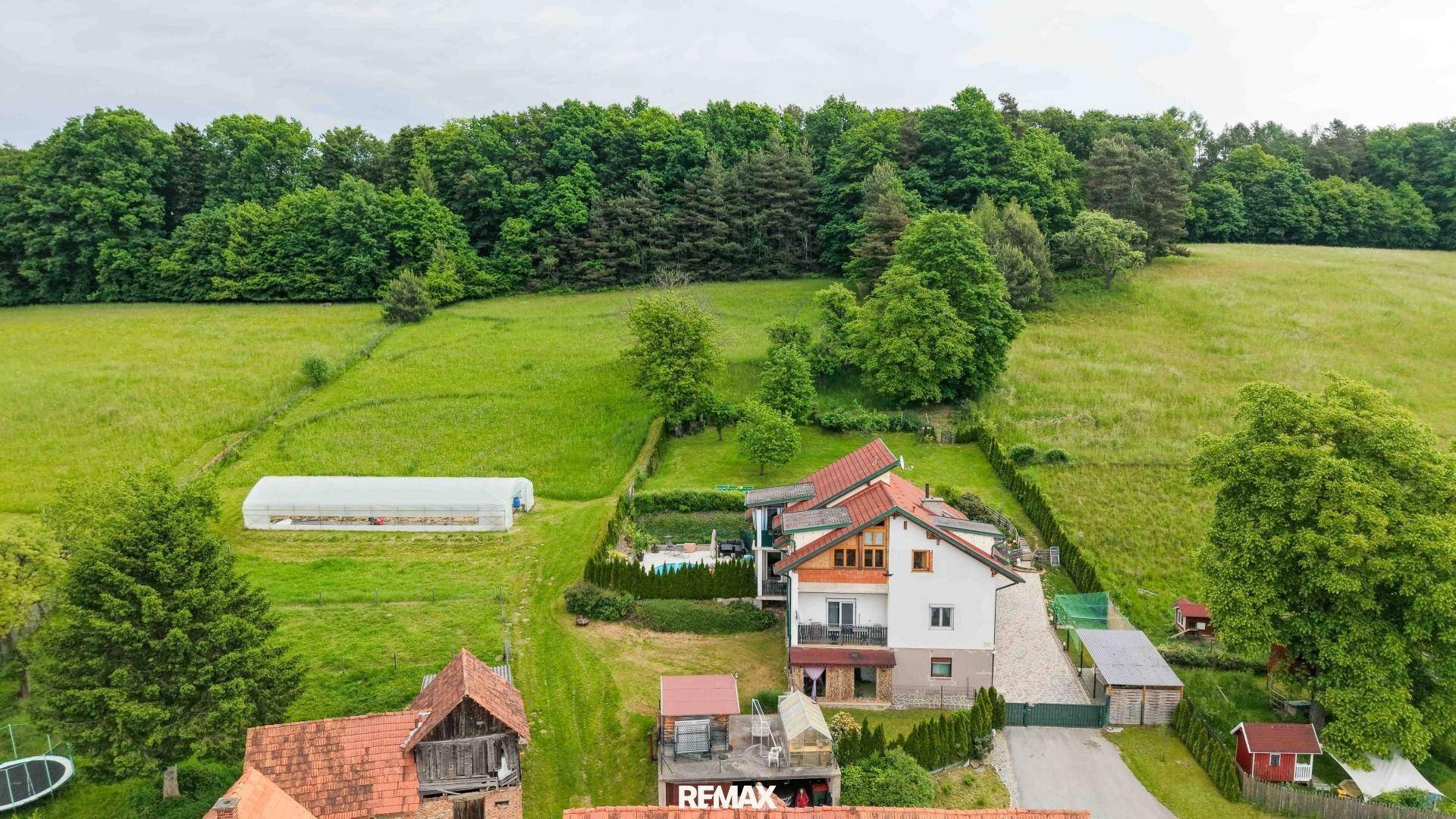 Luftaufnahme des Hauses mit Garten, Zufahrt und angrenzenden Feldern und Wäldern.