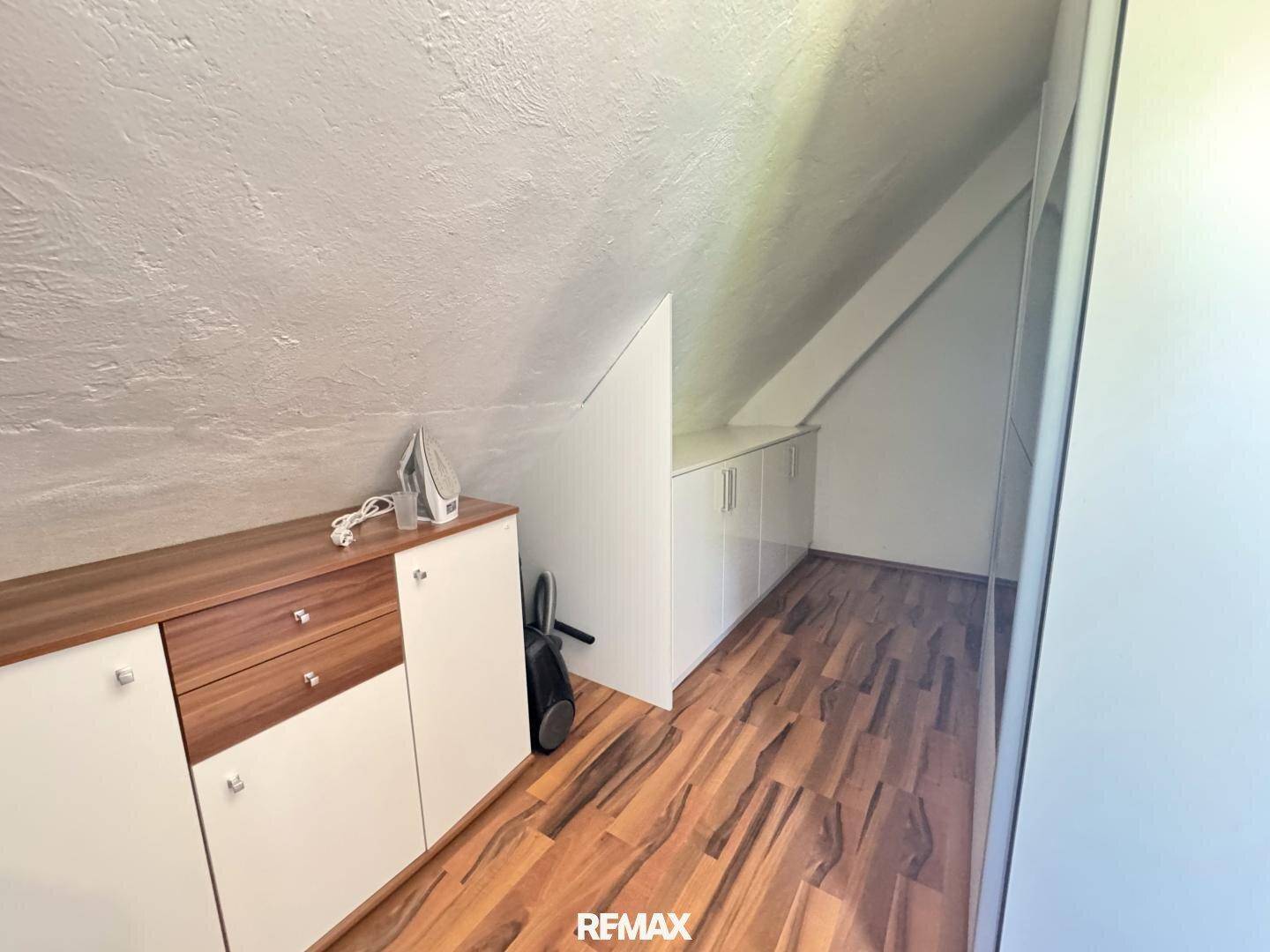 Praktischer Stauraum mit Einbauschränken und Holzboden unter der Dachschräge.