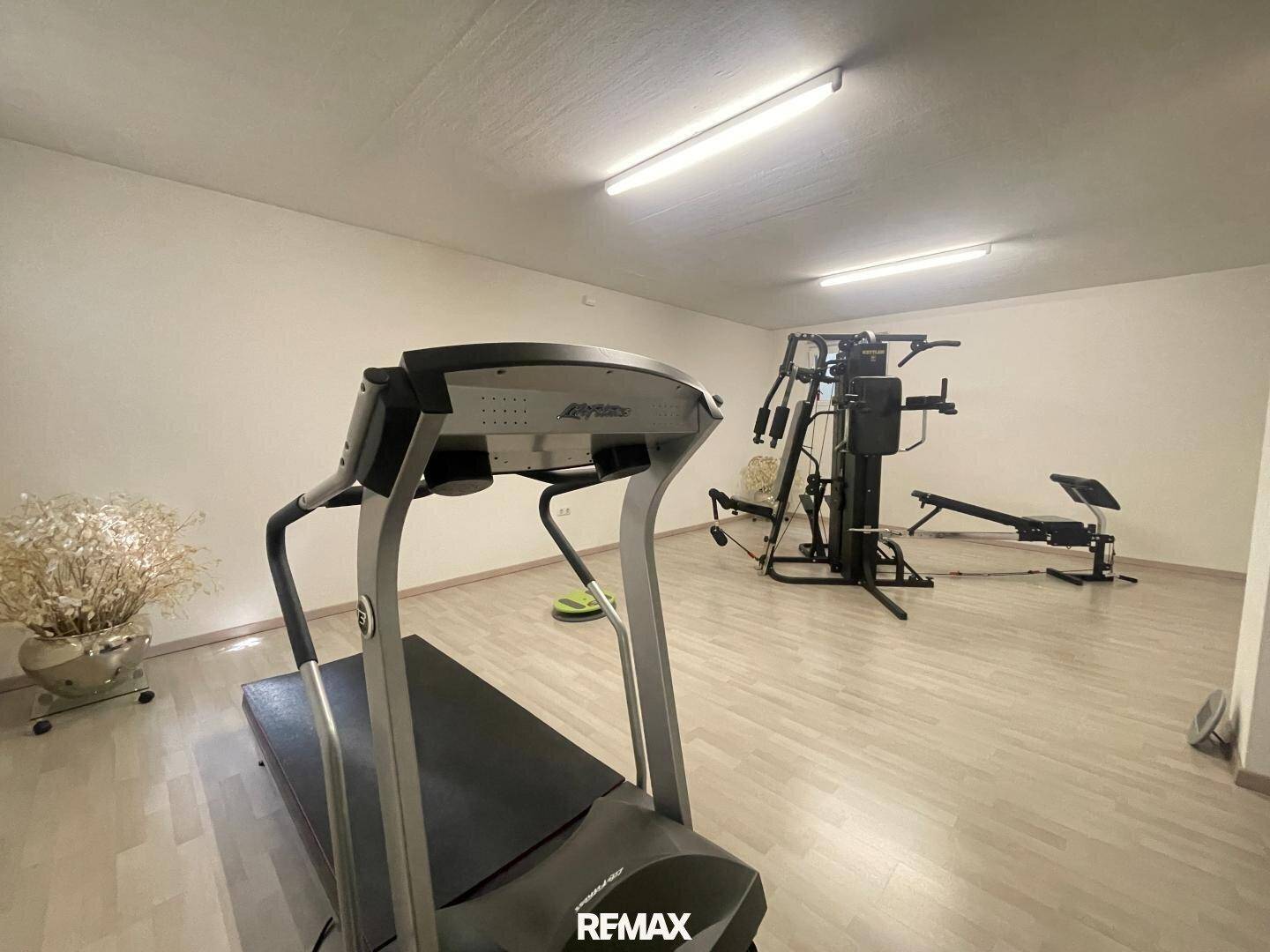Fitnessraum im Untergeschoss mit Laufband und verschiedenen Trainingsgeräten.