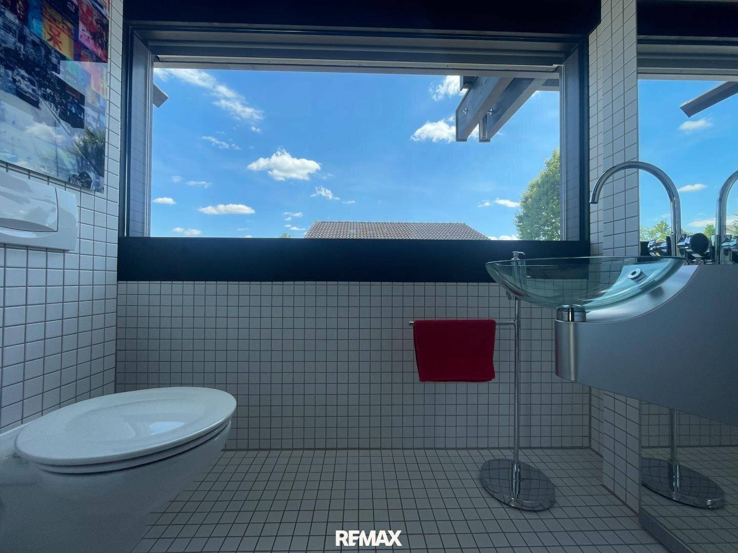 Modernes Gäste-WC mit kleinen weißen Fliesen, Design-Waschbecken und Fenster für Tageslicht.