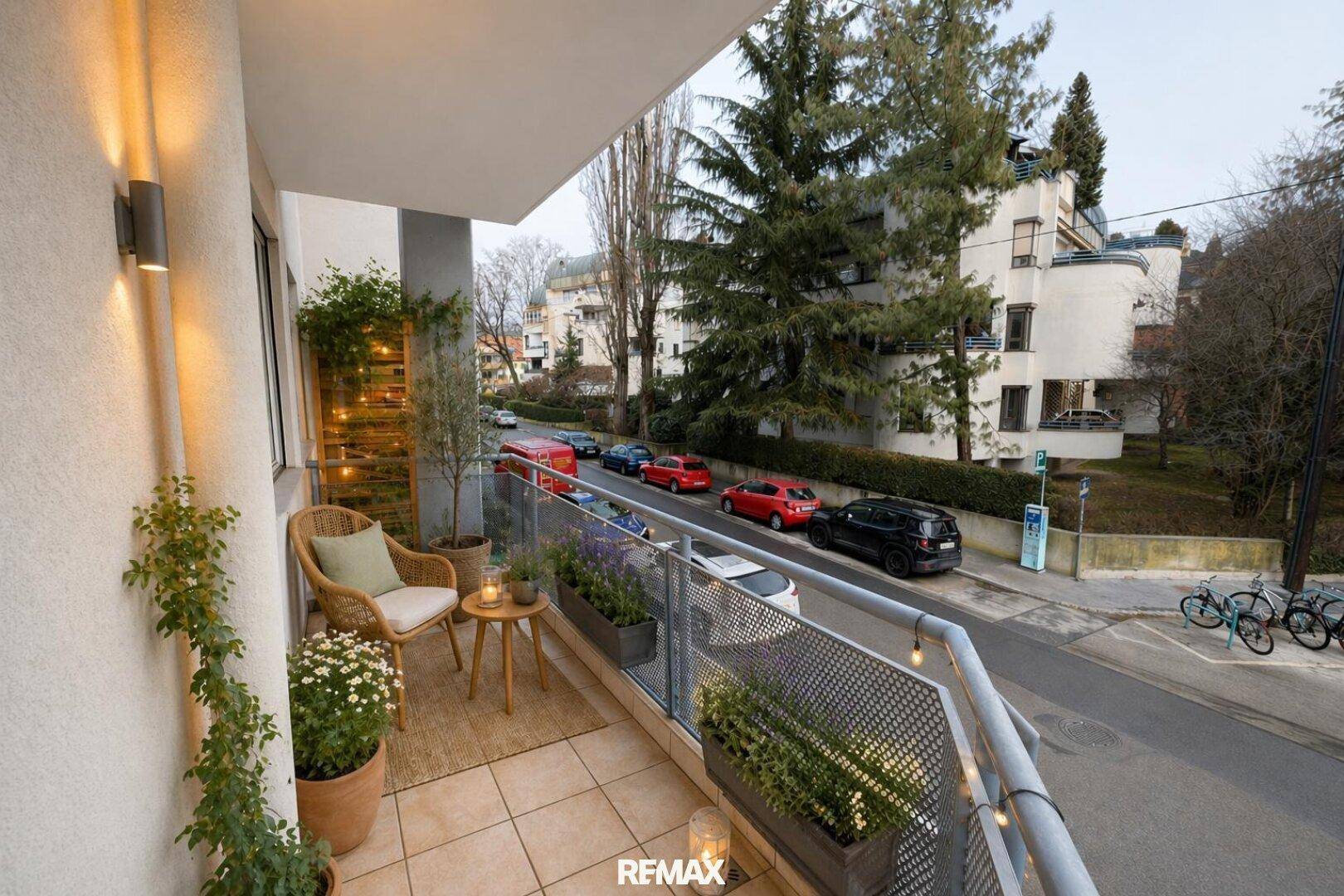 Gemütlicher Balkon mit Sitzgelegenheiten, Pflanzen und Blick auf die belebte Straße.