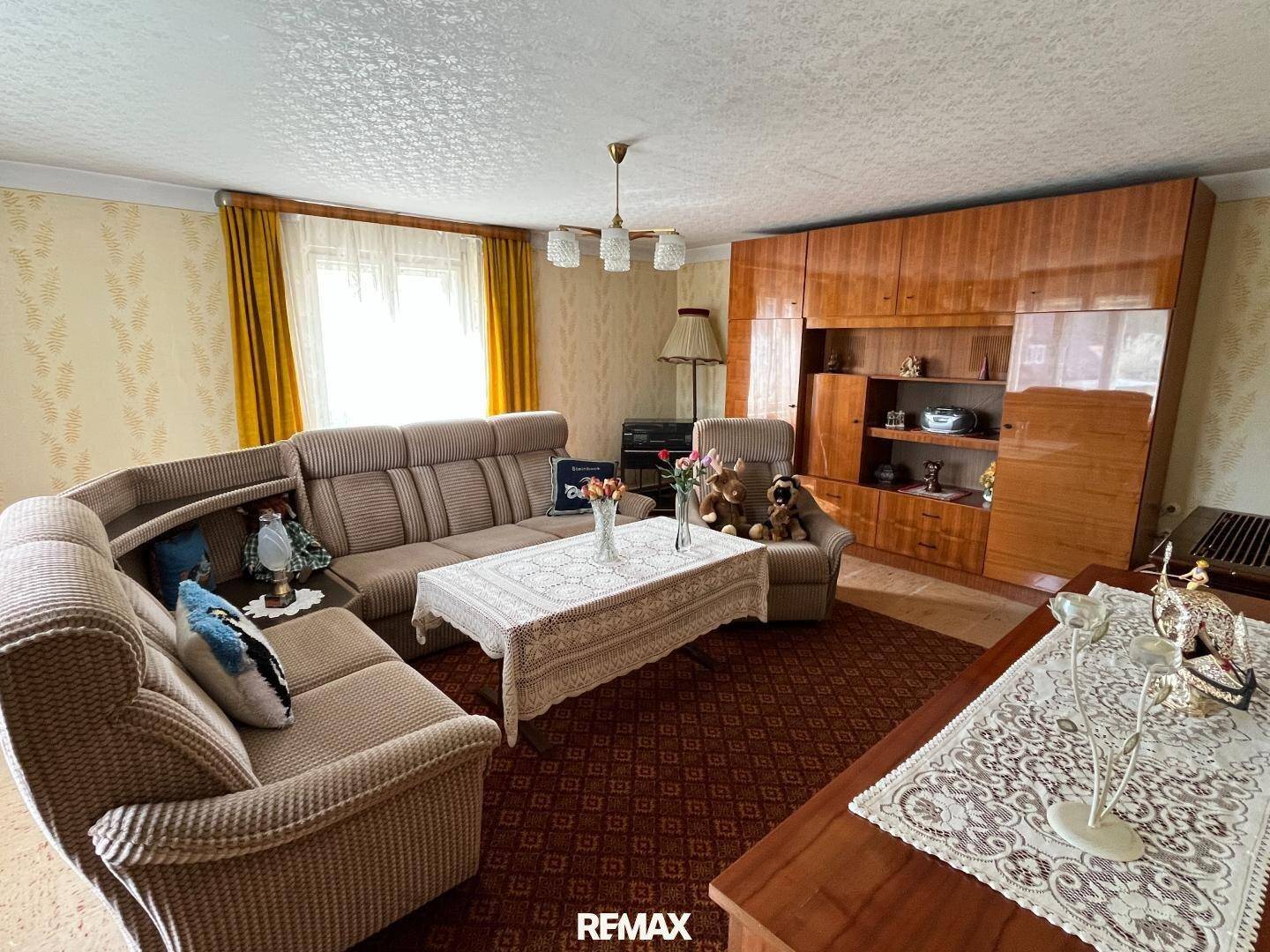 Gemütliches Wohnzimmer mit großem Sofa, Holzmöbeln und traditioneller Dekoration.